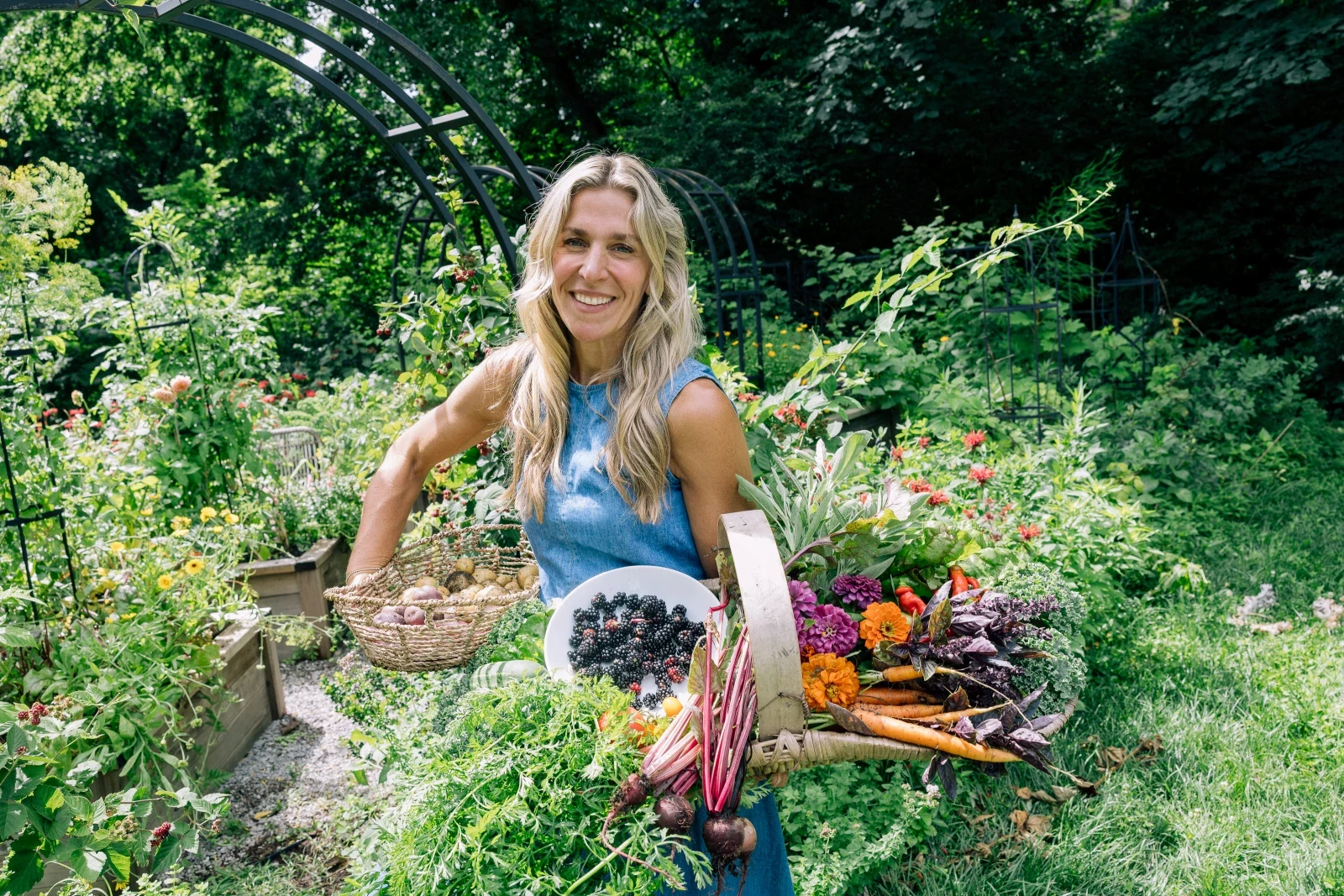 A woman among garden greenery and fresh produce
