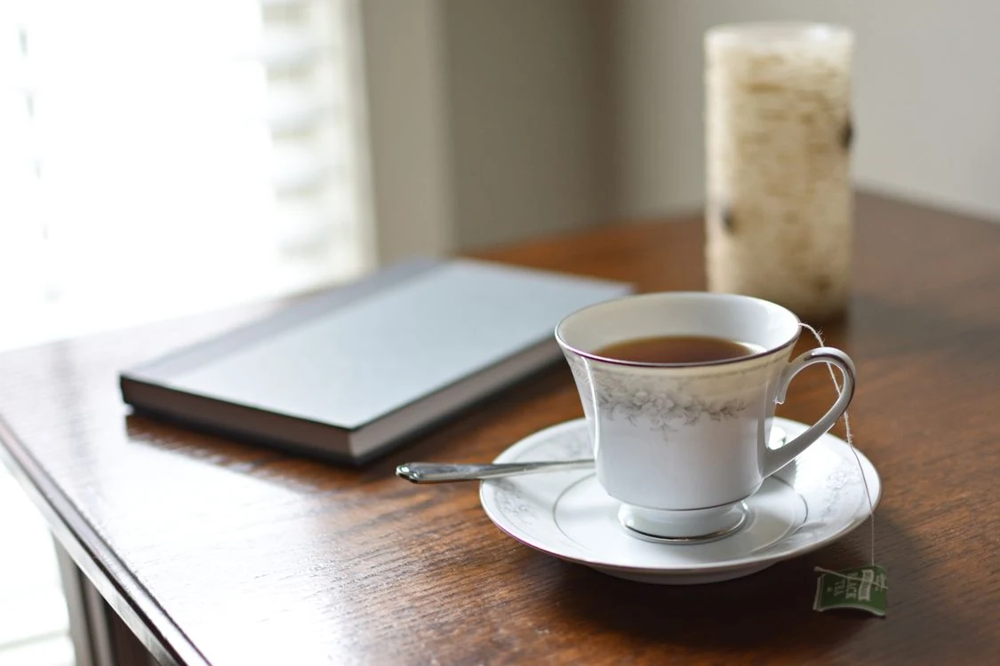 A quiet self-care ritual with tea, a journal, and fresh greenery